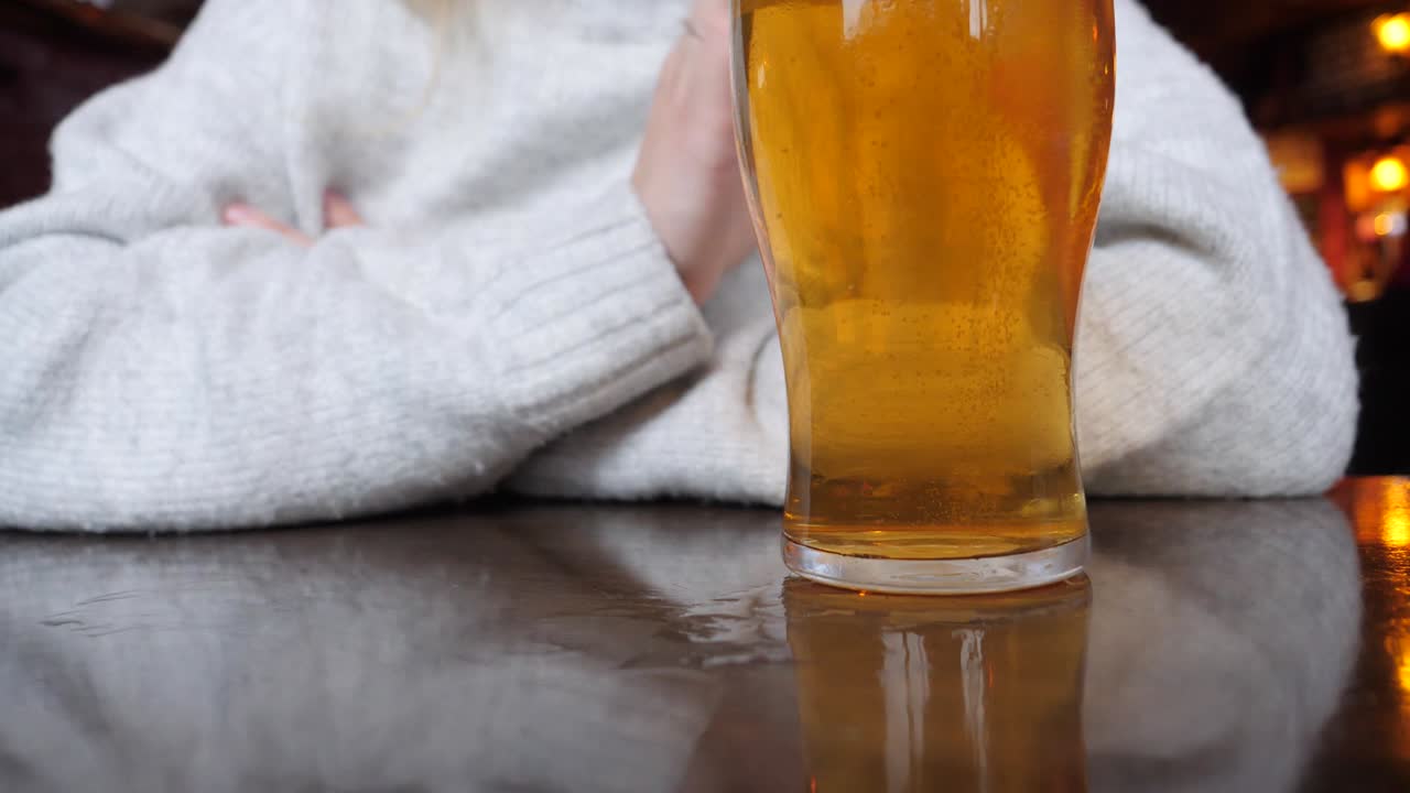 mujer comprometida recoge una pinta de cerveza
