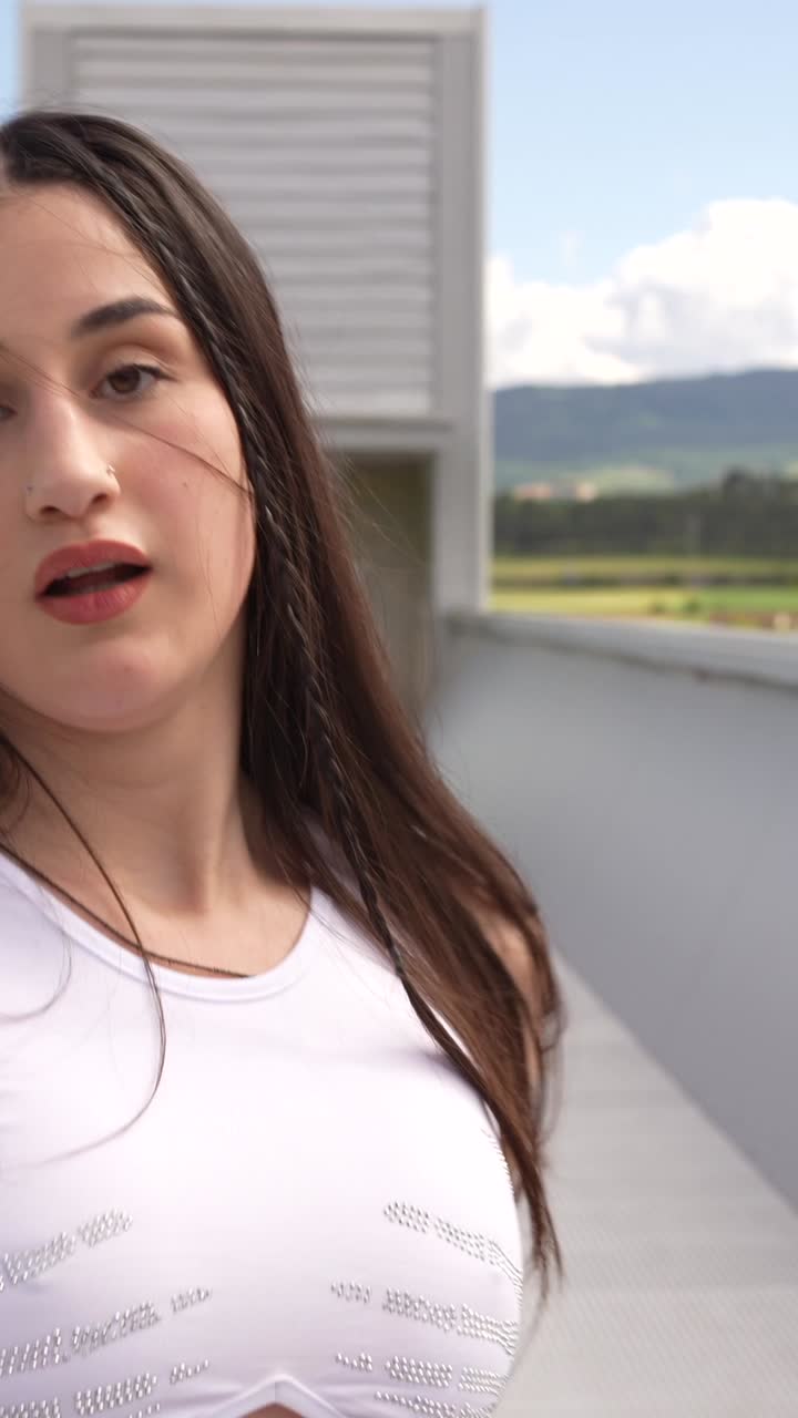 A woman dancing outdoors on an elevated structure