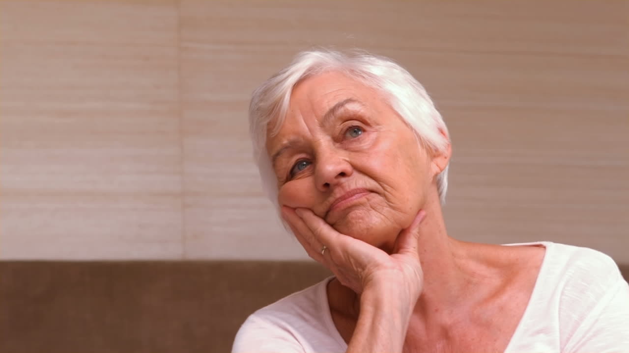 Anziana donna pensierosa nella sua stanza