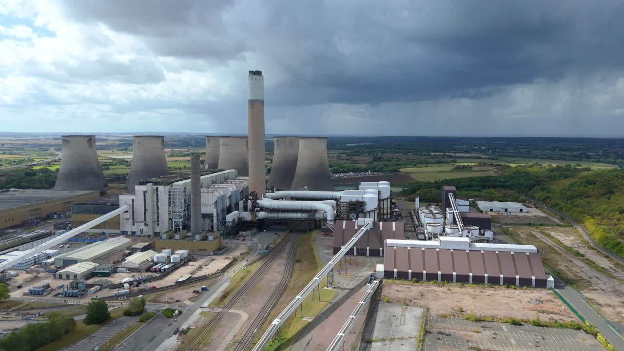 Cinematic aerial shot of decommissioned electricity plant with chimneys and storm clouds near Nottingham, UK