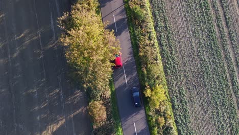 Red-car-overtakes-black-car-on-country-road