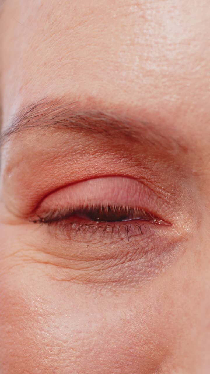 Closeup macro portrait of natural happy mature attractive woman with brown eyes looking at camera