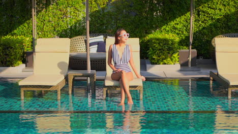 A-pretty-woman-sitting-on-a-beach-lounger-enjoys-a-little-me-time-while-sun-bathing