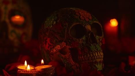 close up on still life of decorated skull surrounded by candles and flower petals celebrating mexican holiday of dia de muertos or day of the dead 2