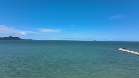 serene seascape: calm ocean with blue sky and distant mountains