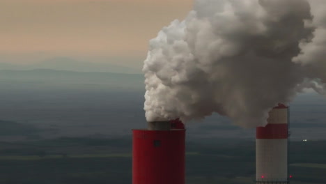 smokestacks emitting pollution over a landscape