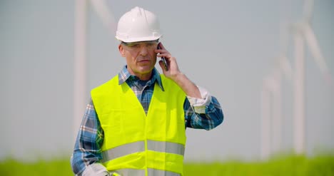 Ingenieur-Spricht-Mit-Handy-Gegen-Windmühlenfarm-1-Farm