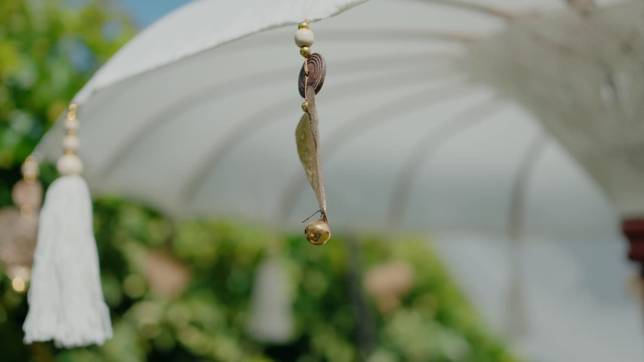 ornamento de corazón de bronce adornado colgando de una sombrilla en un entorno al aire libre sereno