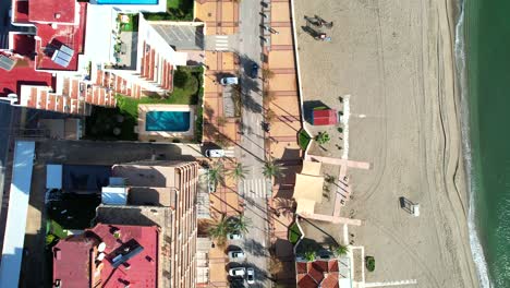 Top-down-view-of-coastal-road-with-luxury-hotels,-gorgeous-sandy-beach