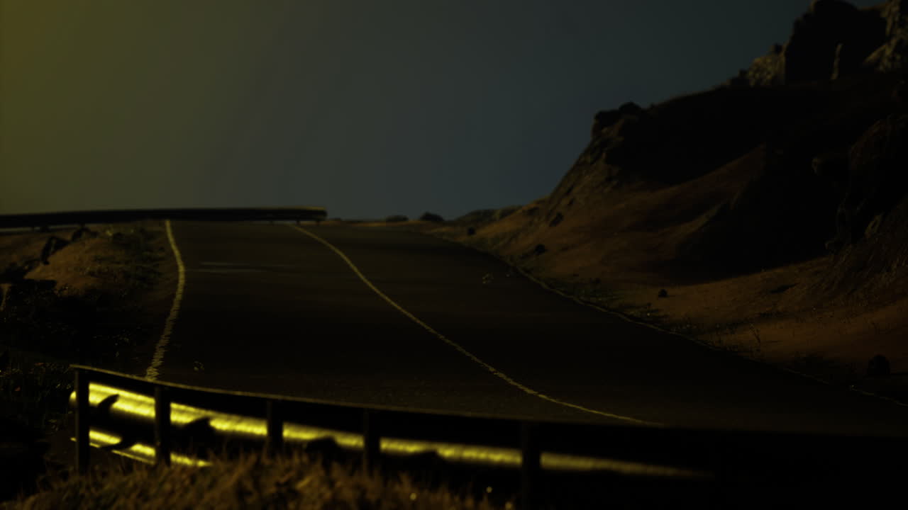 Mysterious night scene on a deserted road surrounded by rocky landscape