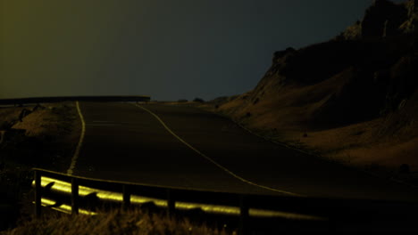 mysterious night scene on a deserted road surrounded by rocky landscape