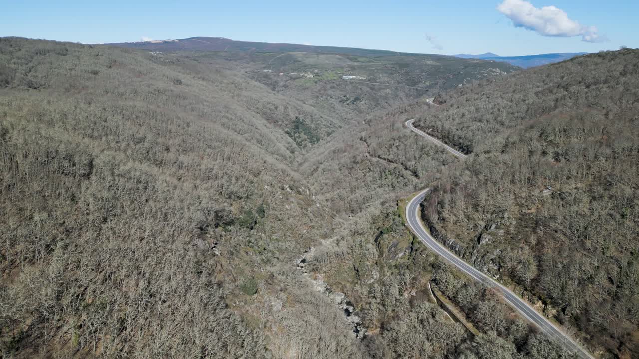 ventos del río navea debajo de la carretera de paso de montaña con bosque nativo sin hojas de robles y castaños