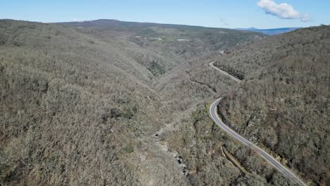 ventos del río navea debajo de la carretera de paso de montaña con bosque nativo sin hojas de robles y castaños