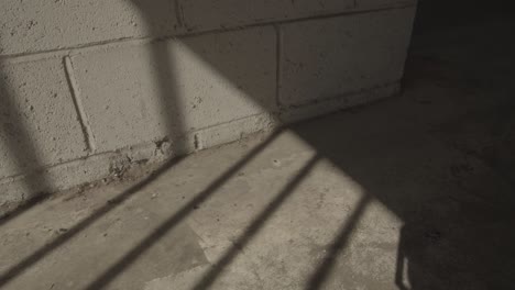 moving gate shadows on concrete wall and floor sunny afternoon jail atmosphere