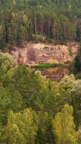 vertical footage of erglu klintis (eagle cliffs), a spectacular sandstone rock cliff from the devonian period preserved for millions of years in the ancient forests of latvia.