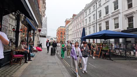 people walking past market stalls in london