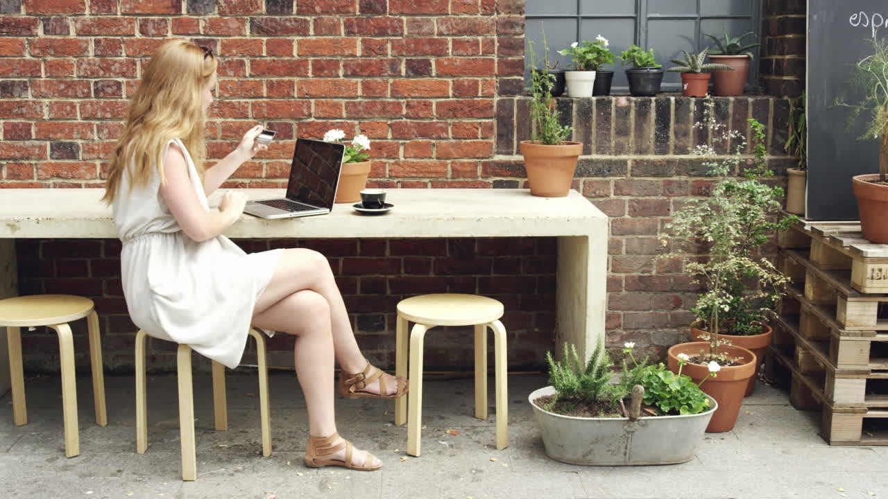 hermosa mujer comprando en línea usando tarjeta de crédito laptop café