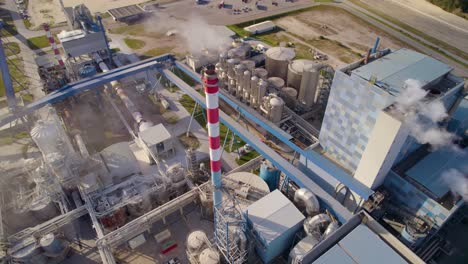 Aerial-tilt-down-shot-of-a-big-industrial-plant-on-a-sunny-day---bird's-eye-view-of-a-modern-cellulose-factory