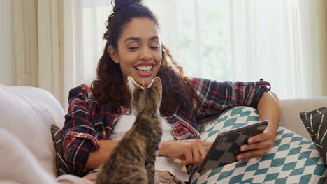 Mujer-Feliz-Sentada-En-El-Sofá-Usando-Su-Tableta-Mientras-El-Gato-Está-Sentado-En-Su-Regazo-4k-4k