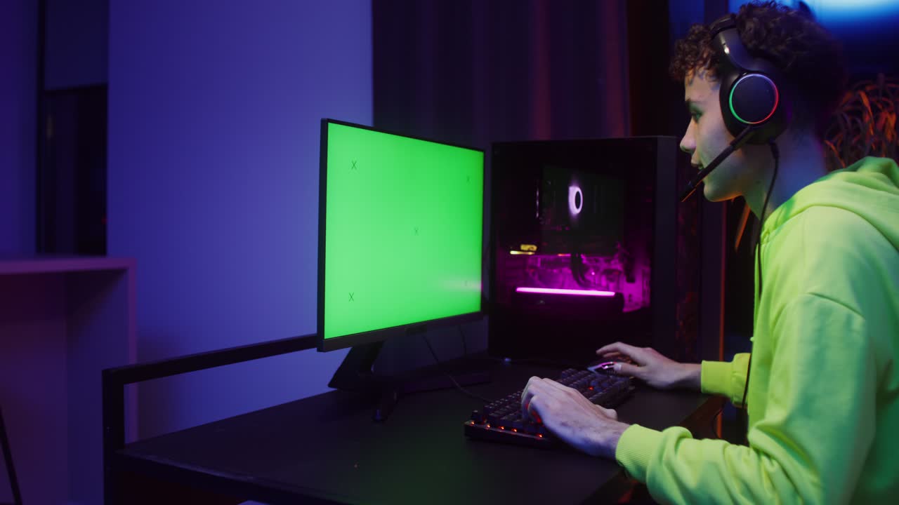 Adolescente che gioca ai videogiochi su un computer con uno sfondo verde