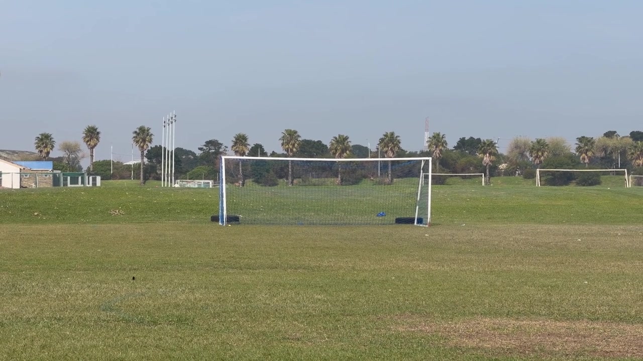 A soccer field in the distance on a soccer club ground.