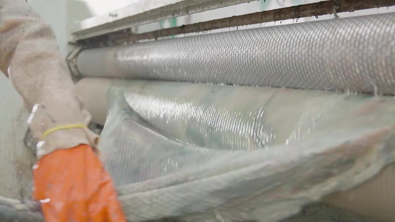 Maschinenbediener in einer industriellen Fertigungsanlage, der Leder aus Tierhäuten herstellt.