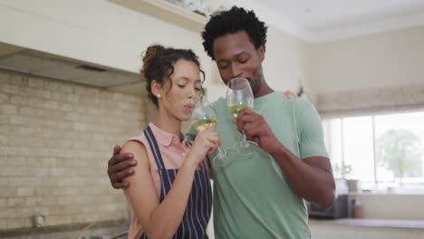 Happy-biracial-couple-cooking-together,-drinking-wine