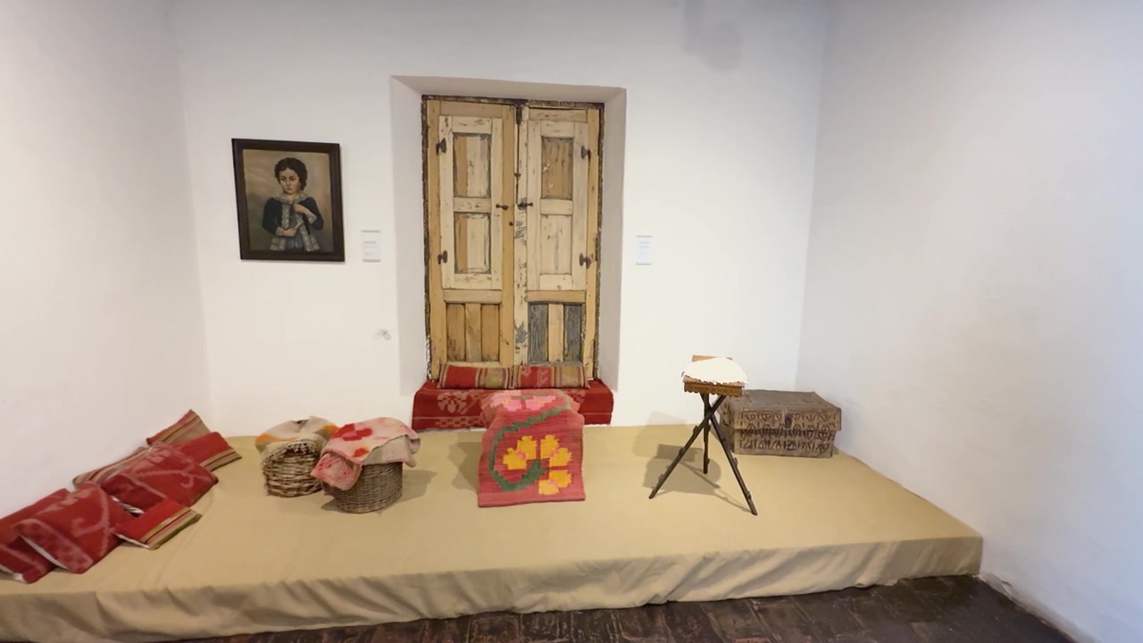 Paneo a la derecha dentro del museo Casa Natal de Sarmiento, mostrando exposiciones históricas rodeadas de paredes blancas y luz interior brillante