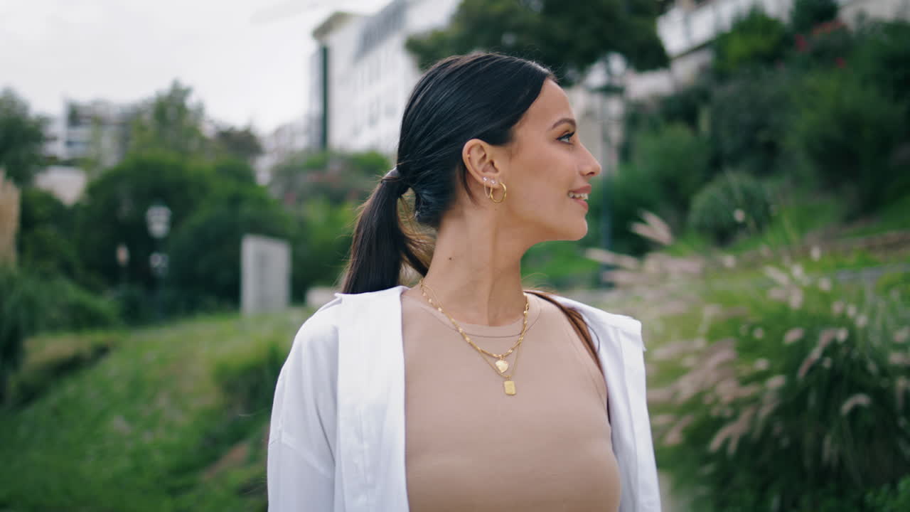 modelo tierno cruzando el parque paisaje de primer plano. alegre despreocupado inspeccionando la naturaleza