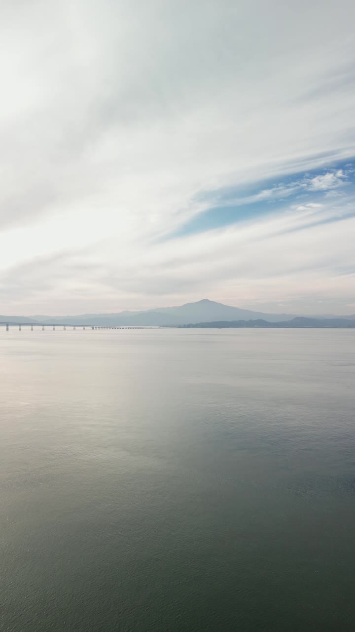 An reveal of the ocean bay between the Richmond–San Rafael Bridge and Point Molate Beach. Filmed on a drone in 4K.
