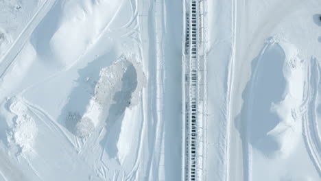 aerial view of snow-covered industrial conveyor belt