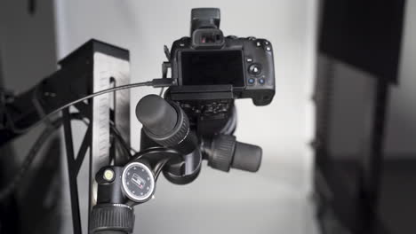 professional camera on a tripod in a studio with a backdrop screen