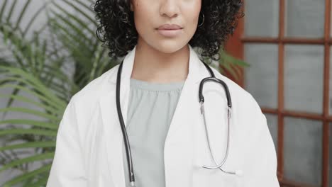 retrato de una doctora biracial con una bata de laboratorio, usando una tableta, en cámara lenta.