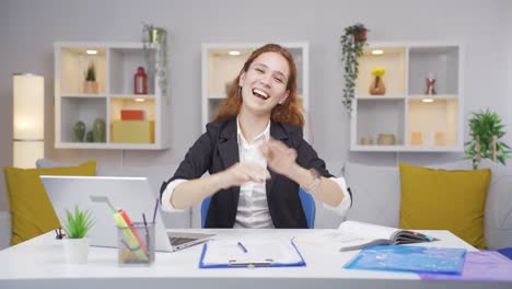 home office worker woman makes heart symbol looking at camera.