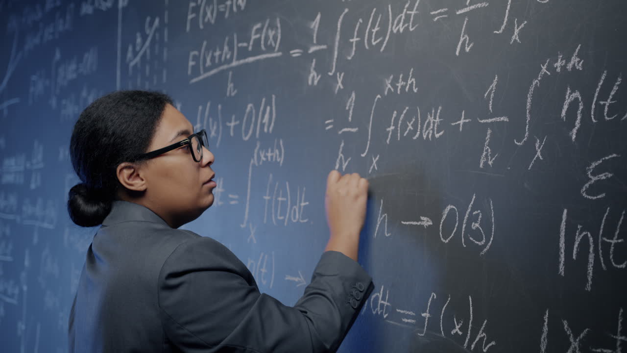 Woman writing equations on a chalkboard