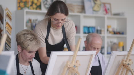 a woman helps the elderly learn to draw