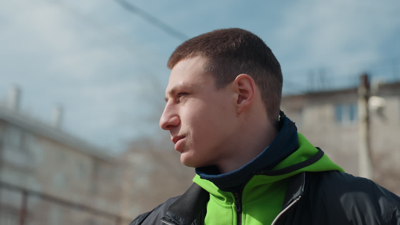 Joven deportista urbano entrenando; joven deportista decidido en una cancha de baloncesto urbana al aire libre; joven deportista adolescente concentrado practicando baloncesto en una cancha de la ciudad a la luz del día