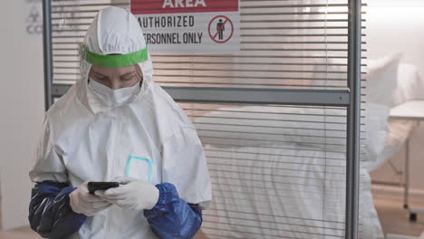 doctor using smartphone outside hazardous area