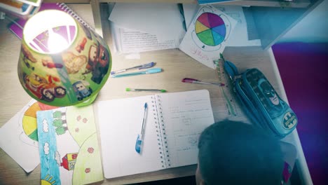 child doing homework at night on his desk