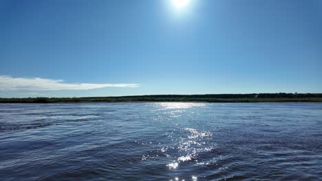 Eine-Wunderschöne-Aussicht-Auf-Einen-Fluss-An-Einem-Sonnigen-Tag,-Mit-Blauem-Himmel-Und-Glitzerndem-Wasser