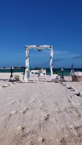 outdoor wedding party gazebo decorated with white flowers on caribbean sandy beach