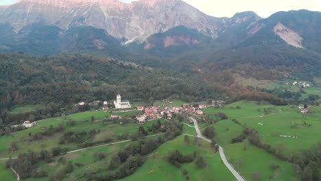 circular aerial shot of dreznica village below majestic mountains, early autumn evening
