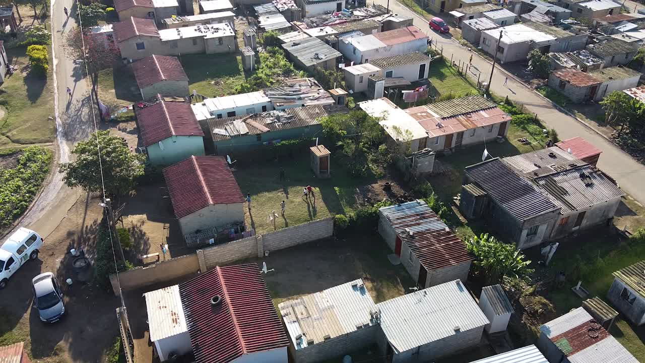 una foto de un dron de un pueblo zulú mientras los niños juegan al fútbol