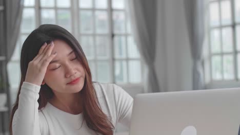 woman with headache at laptop