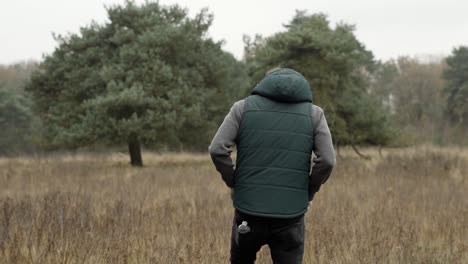 man walking into the forest and feels his pockets because he thinks he forgot something