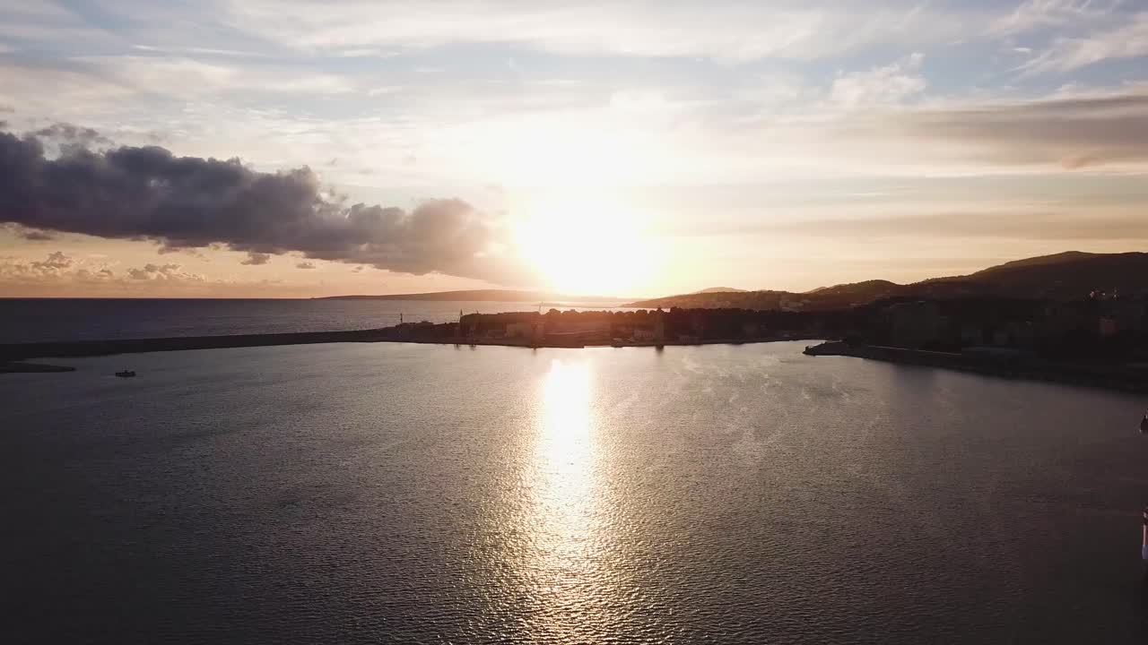 해안 도시 위의 해가 지는 모습