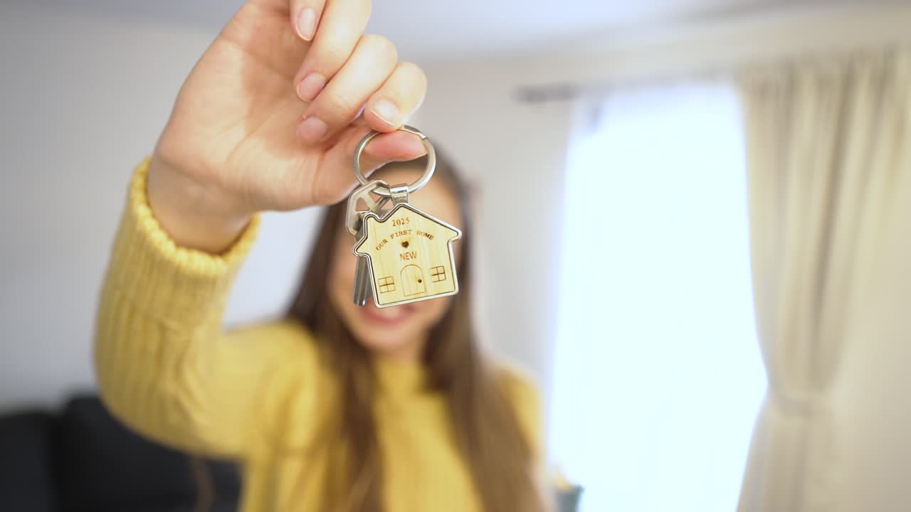 Una donna felice mostra la chiave della sua nuova casa, raggiante di gioia. L'attenzione è focalizzata sulla chiave lucente, che simboleggia nuovi inizi, sogni realizzati e un nuovo capitolo della vita.