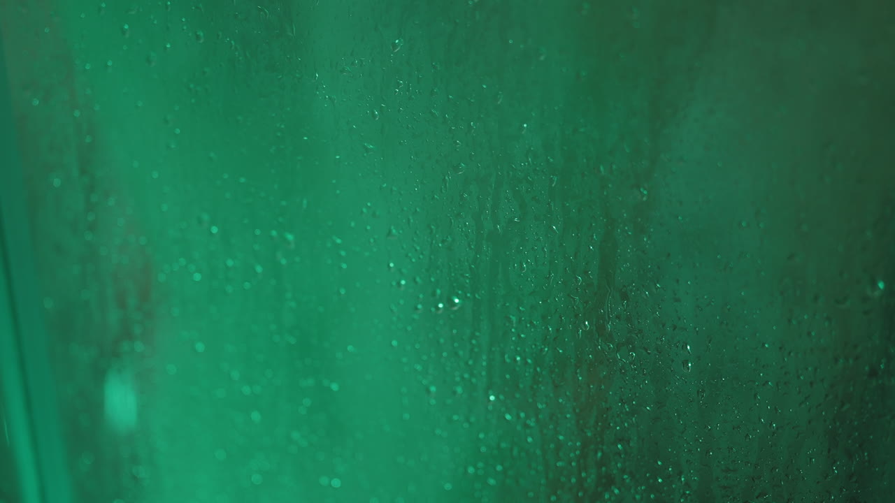 gotas de agua en una ventana verde