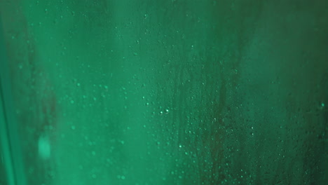 gotas de agua en una ventana verde