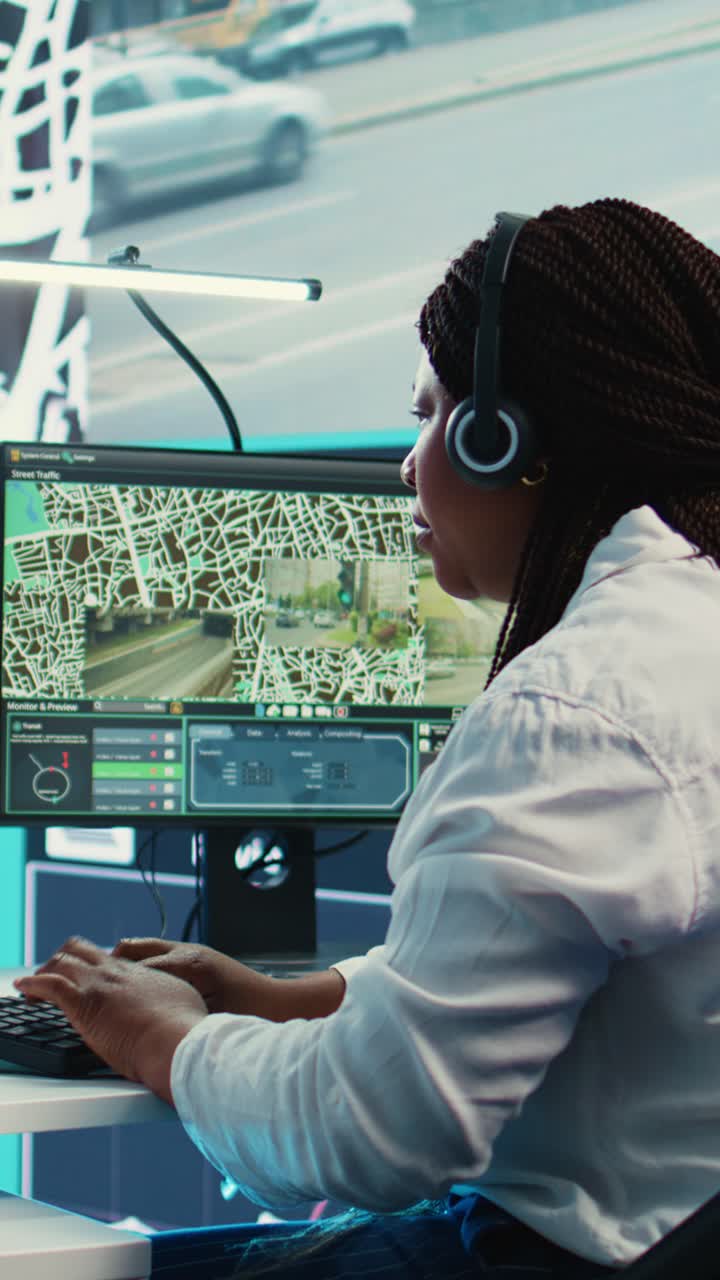 Donna afroamericana che monitora il sistema di sorveglianza della città nella sala di controllo